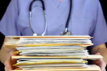 doctor holding stack of files and papers